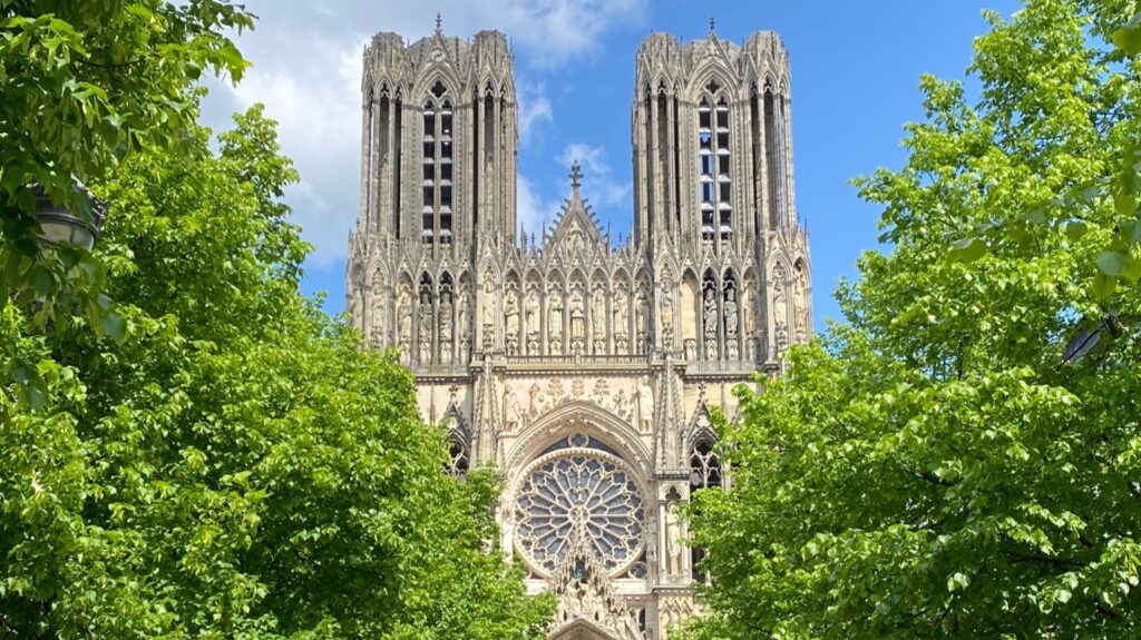 Reims Cathedral framed by green trees
