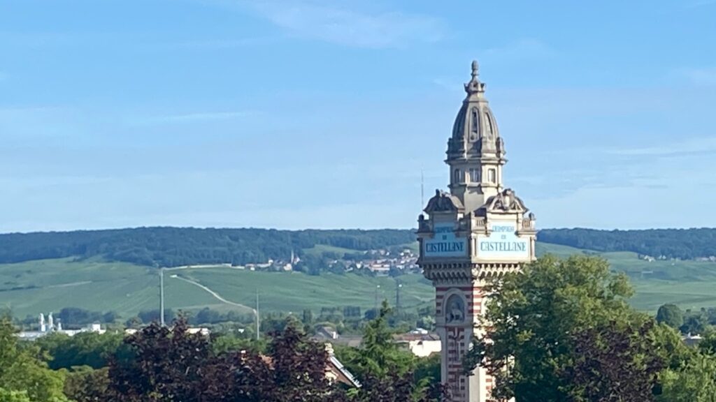 Champagne vineyards and Castellane tower in Epernay under a clear blue sky