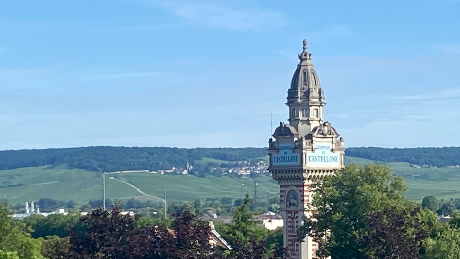 Champagne vineyards and Castellane tower in Epernay under a clear blue sky
