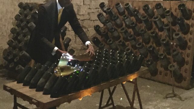 Traditional Champagne riddling table (pupitre) demonstration inside the Veuve Clicquot cellars in Reims